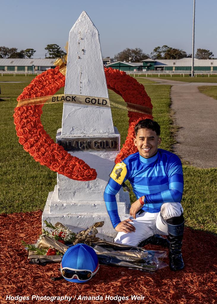 Jockey Jeiron Barbosa who rode Tom's Magic to victory in the 67th running of the Black Gold Stakes places the traditional bouquet at the grave of Black Gold in the Fair Grounds infield. (Hodges Photography / Amanda Hodges Weir)