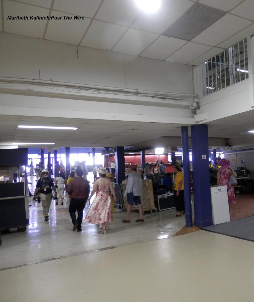 Ladies in fancy hats and pretty dresses swish through the Pimlico grandstand. (Maribeth Kalinich/Past The Wire)