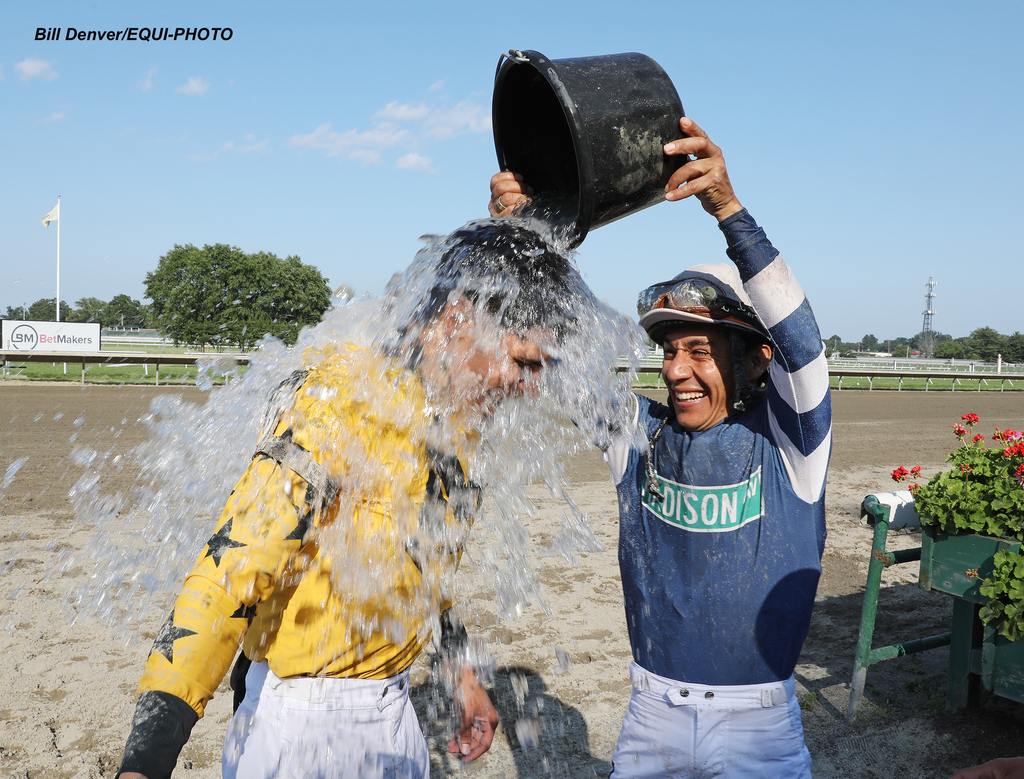 Jockey Paco Lopez pours a bucket of ice on the head of Jockey Jorge A. Vargas, Jr. after Vargas scored his 1,000th career victory in the last race at Monmouth Park Racetrack in Oceanport, NJ on Friday July 4, 2025 aboard Gran Yaco. Photo By Bill Denver/EQUI-PHOTO