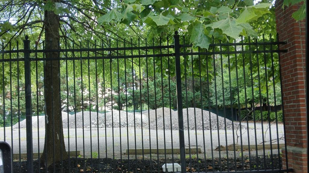 Gravel piles sit inside Pimlico's wrought iron fence. (April Inloes Smith)